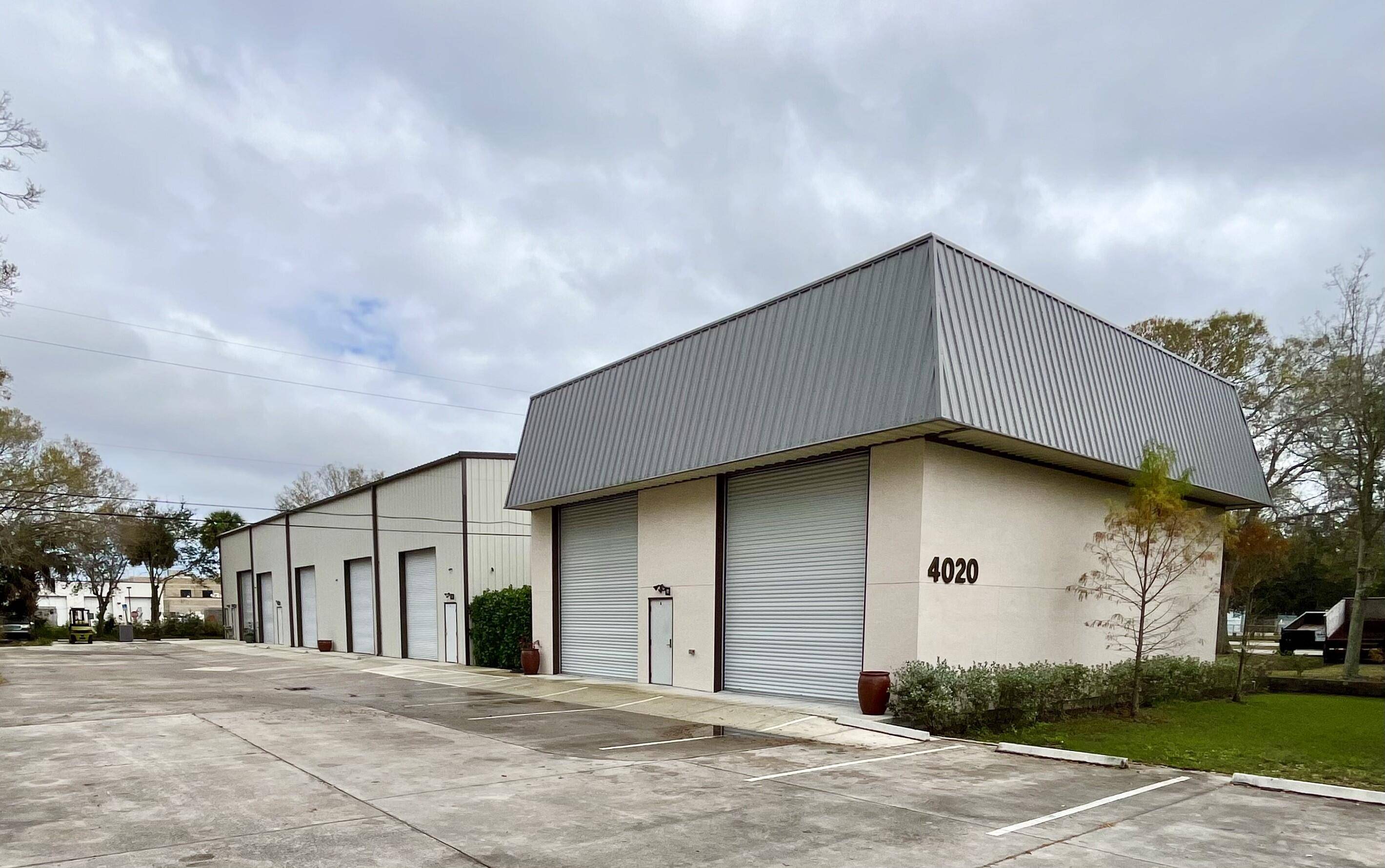 Rigid Red Iron Heavy Commercial Beam Steel Frame concreet block stucco Warehouse with Metal roof featuring 4 storage units.