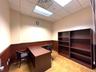 Office space with a wainscoted wall, a drop ceiling, and light wood-style flooring
