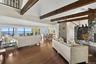 Living area with dark wood-type flooring, a water view, and a chandelier