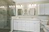 Bathroom featuring tile patterned floors, vanity, toilet, and a shower with shower door