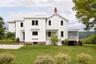 View of front of house featuring a chimney, a front yard, a standing seam roof, and a metal roof