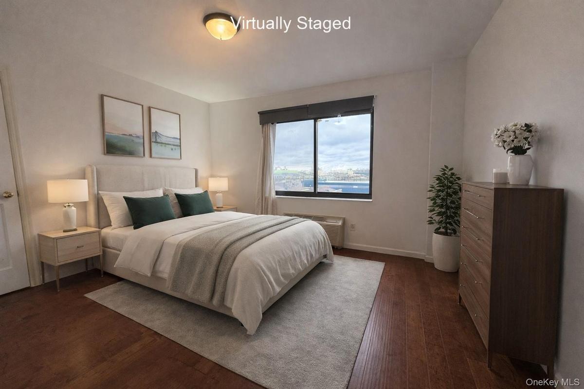 Bedroom with dark wood finished floors and baseboards