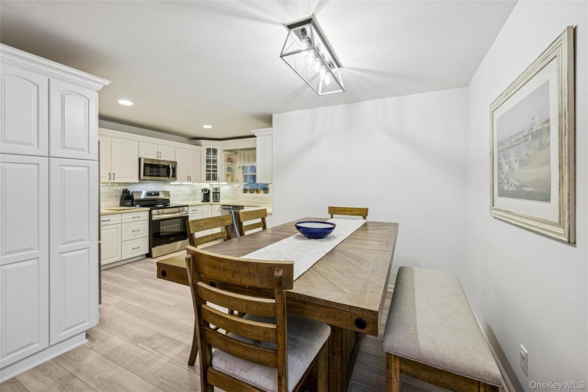 Dining area with recessed lighting and light wood-type flooring