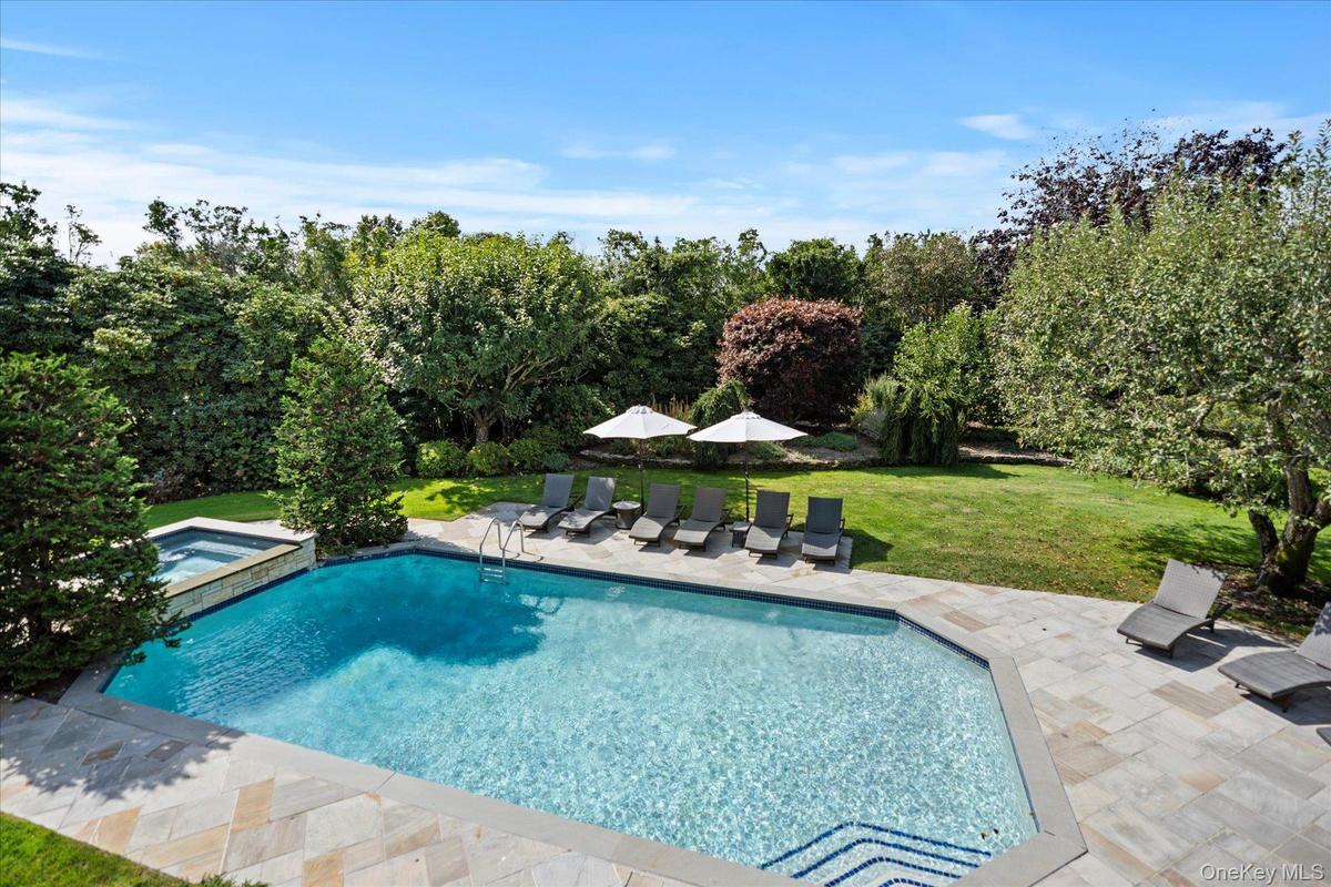 View of swimming pool featuring a lawn, a patio area, and a pool with connected hot tub