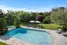 View of swimming pool featuring a lawn, a patio area, and a pool with connected hot tub
