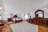 Spacious room featuring wood-finish flooring, white walls, and a sloped ceiling