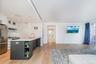 Kitchen featuring white cabinets, open shelves, hanging light fixtures, and light wood finished floors