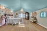 Bedroom with a chandelier, light wood-type flooring, lofted ceiling, and wallpapered walls