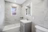 Bathroom featuring a light gray vanity, integrated sink, and an illuminated mirrored medicine cabinet