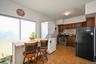 Kitchen with freestanding refrigerator, decorative backsplash, stainless steel gas stove, stacked washer / dryer, and dark countertops
