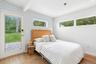 Bedroom featuring light wood-style floors, beamed ceiling, and access to outside