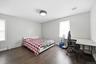 Spacious room featuring wood-finish flooring, light grey painted walls, and white baseboards