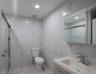 Full bath featuring a marble finish shower, tile walls, vanity, and marble tiled floors