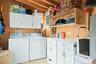 Laundry area featuring wood walls, cabinet space, and washer and clothes dryer