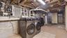 Laundry area with tile patterned floors, electric panel, gas water heater, separate washer and dryer, and laundry area