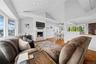Living room with a wainscoted wall, wood finished floors, a decorative wall, lofted ceiling, and recessed lighting