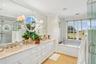 Full bath with a shower stall, double vanity, ornamental molding, light tile patterned flooring, and a garden tub