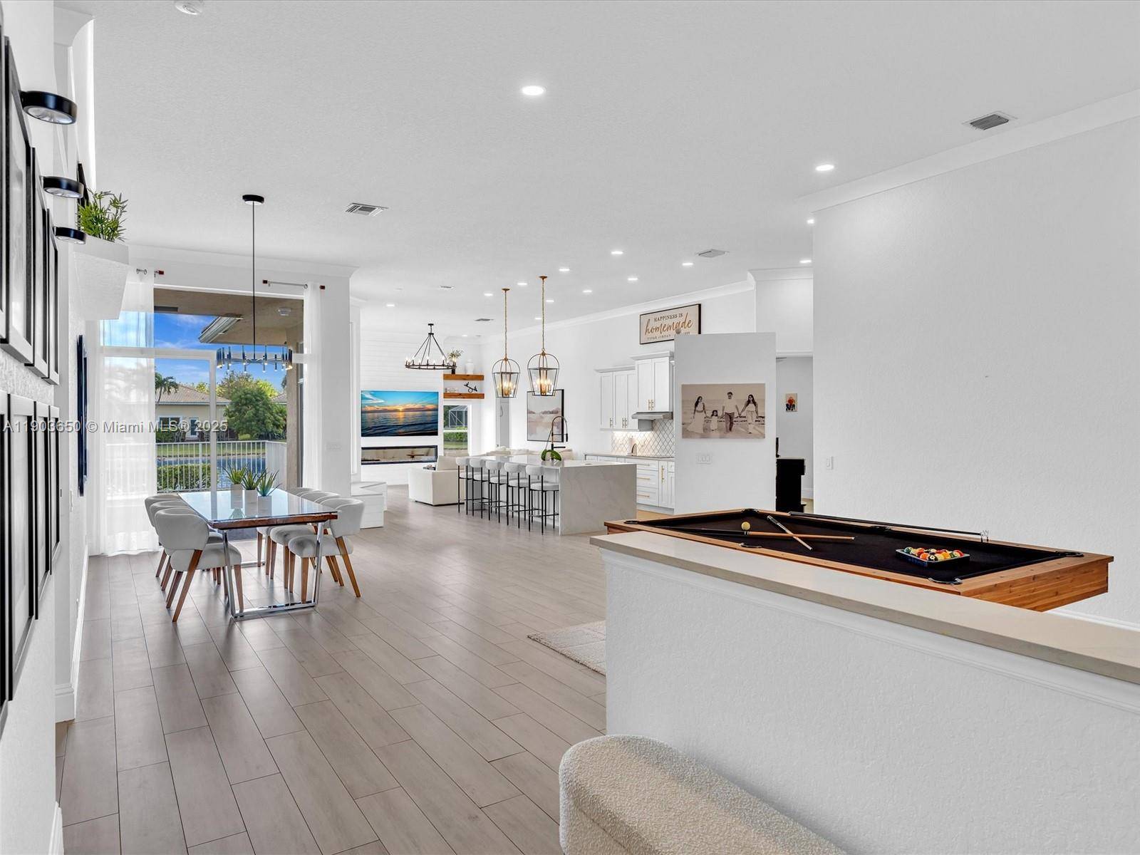 Stunning Waterfront pool home in Wyndham lakes gated community, featuring modern open triple split plan w 12 ft ceilings.