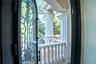 Arched black iron doors open to a private lanai off the spa-inspired marble bath with sauna, soaking tub, and custom detailing.