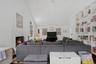 Living room with wood finished floors, high vaulted ceiling, a fireplace, and built in shelves