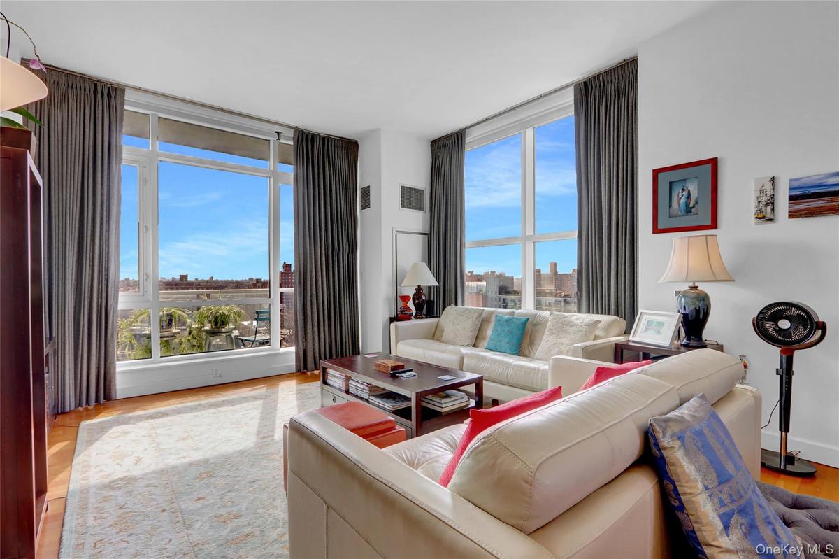 Living room with wood finished floors, expansive windows, and a view of city