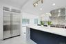 The oversized waterfall island serves as the centerpiece of this sophisticated kitchen, complemented by a Sub-Zero refrigerator/freezer and abundant s