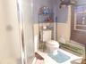 Bathroom with wainscoting, a stall shower, and tile patterned flooring
