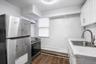 Ground floor apartment kitchen with stainless steel fridge and electric stove.