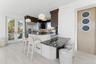 Kitchen with dark stone countertops, a kitchen bar, and light wood finished floors