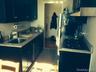 Kitchen featuring blue cabinets, exhaust hood, and dark tile patterned flooring