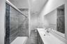 Full bathroom with vanity, a stall shower, and dark stone finish flooring