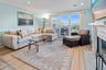 Living area with a fireplace with flush hearth, recessed lighting, wood finished floors, visible vents, and crown molding