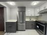 Kitchen featuring appliances with stainless steel finishes, white cabinetry, under cabinet range hood, and modern cabinets