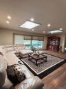 Living area with a skylight, wood finished floors, recessed lighting, and a baseboard radiator