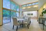 The elegant dining room is surrounded by walls of glass and opens effortlessly to outdoor entertaining spaces.