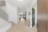 Entryway into the home with built in storage bench to the left and guest bedroom with double doors to the right