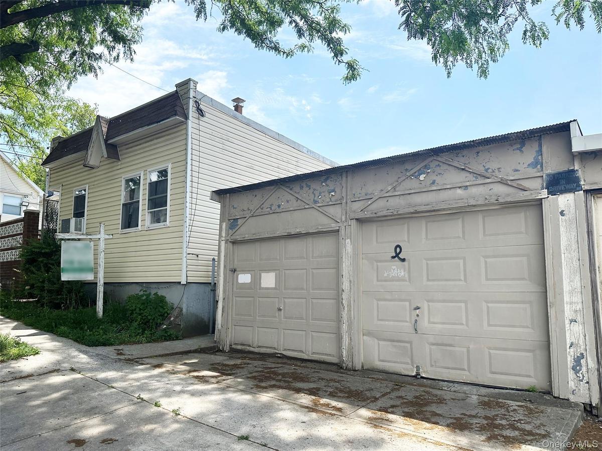 Front of the 1-family building, and part of the 3-car garage.