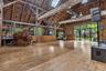 Soaring post-and-beam great hall with expansive glass doors opening to the surrounding gardens