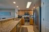 The L-shaped layout maximizes counter space and efficiency and recessed ceiling lights for a bright and modern feel.
