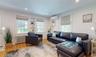 Living room featuring radiator heating unit, a wall mounted AC, and light wood-type flooring