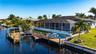 Canal view of deck, boat life, tiki hut, full lanai