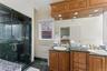Full bathroom with double vanity and a marble finish shower