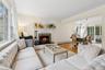 Living room with a fireplace, wood finished floors, baseboard heating, a chandelier, and ornamental molding