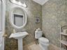 Elegant first floor powder room with wallcovering.