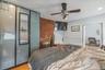 Bedroom featuring light wood-type flooring, a ceiling fan, brick wall, recessed lighting, and a baseboard radiator