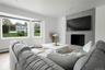 Living area featuring wood finished floors, a tiled fireplace, recessed lighting, and a baseboard heating unit