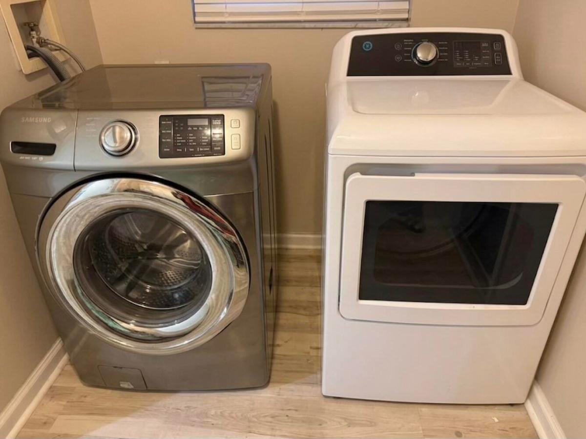Dedicated laundry area featuring a front-loading washing machine and a top-loading dryer