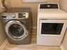 Dedicated laundry area featuring a front-loading washing machine and a top-loading dryer