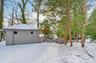 Snow covered garage featuring a detached garage