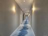 Corridor with a textured wall, recessed lighting, and concrete flooring